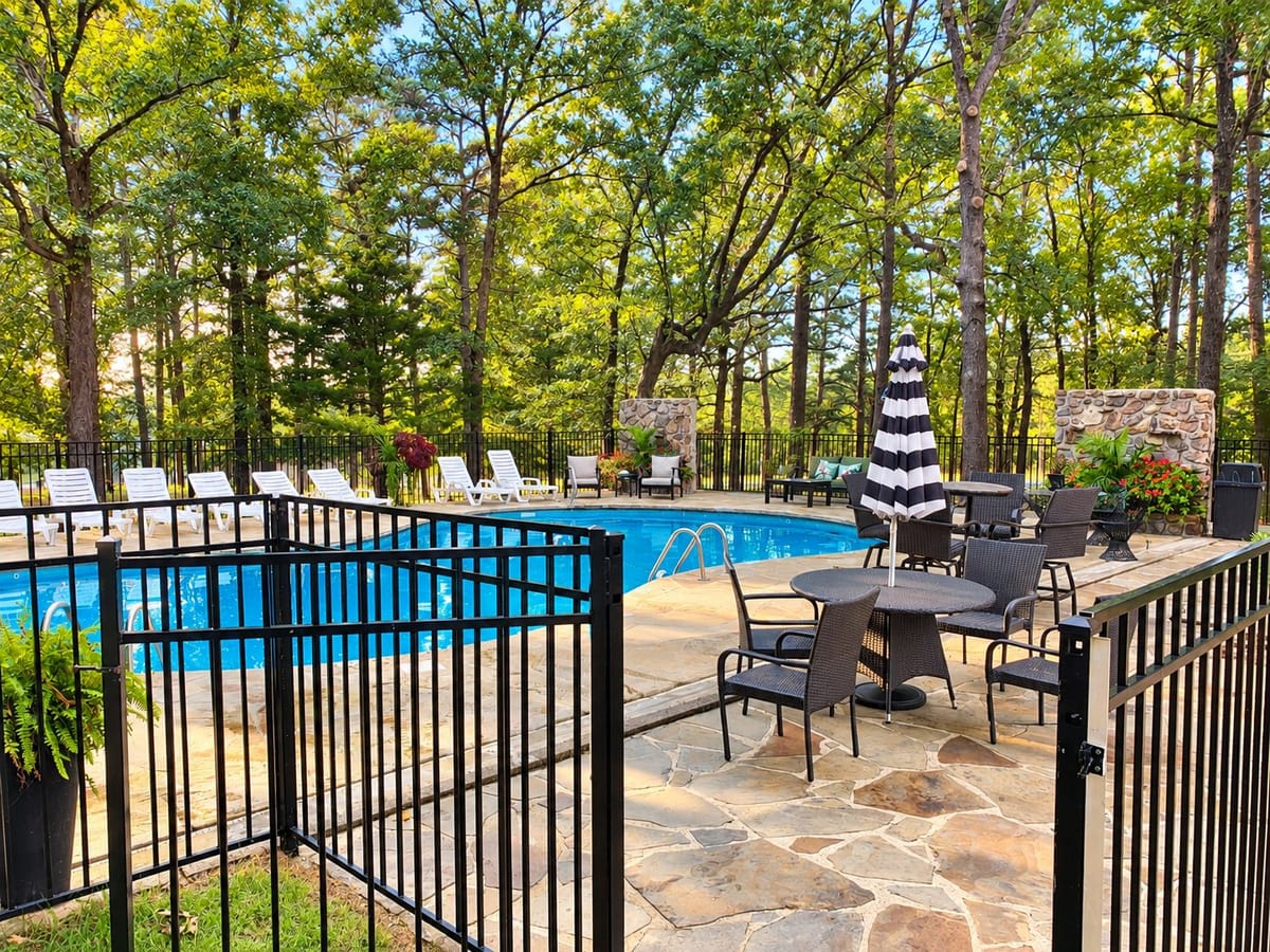 Pool deck with tables, umbrellas and the stone waterfall wall