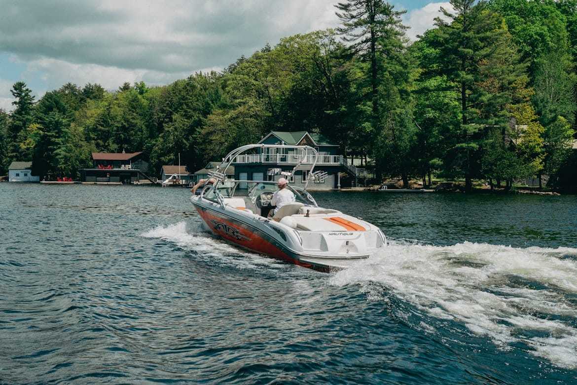 A speedboat on the lake with forest behind